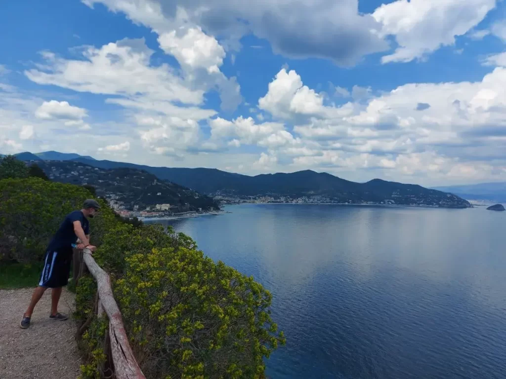 Jan guckt am Ausblick auf die Palmenriviera, die Küste von Noli vom Capo Noli aus, in die Tiefe