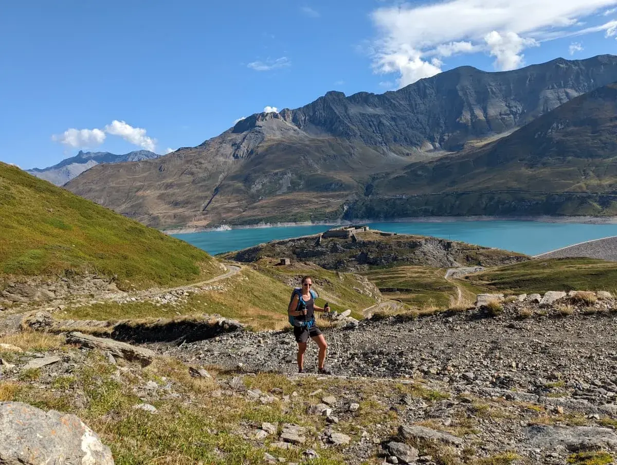 Linda auf einem Wanderweg auf dem Col du Mont Cenis oberhalb des Forts de Variselle. Im Hintergrund der blaue Stausee und die schroffen Alpen.
