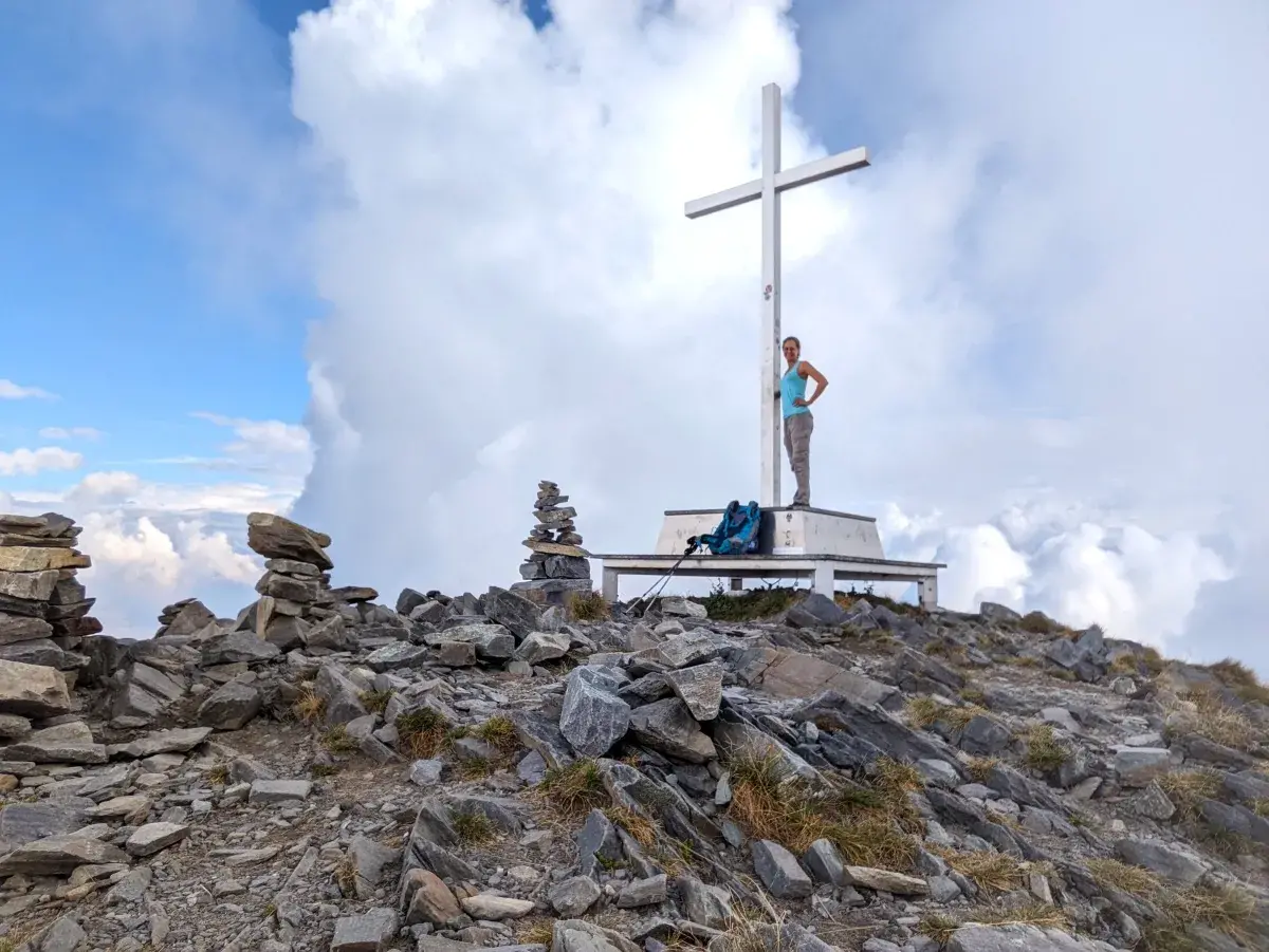 Linda steht am Gipfelkreuz auf dem Monte Tamaro