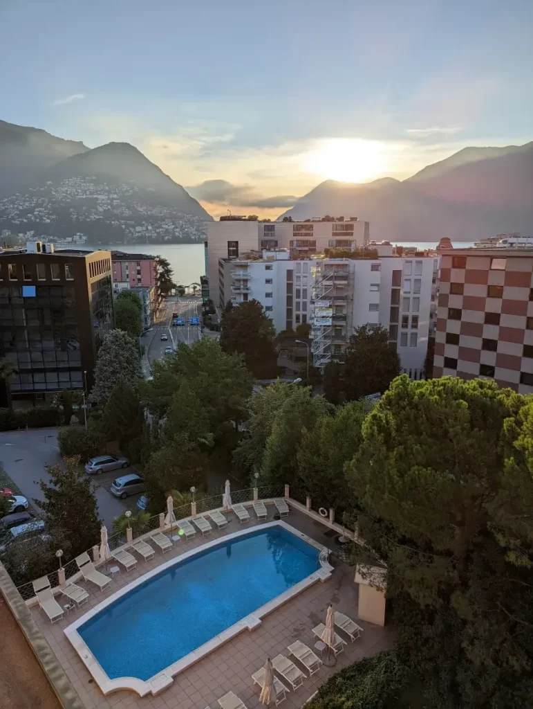 Blick von meinem Balkon im Hotel de la Paix auf den Hotelpool, den Luganersee und Monte Brè