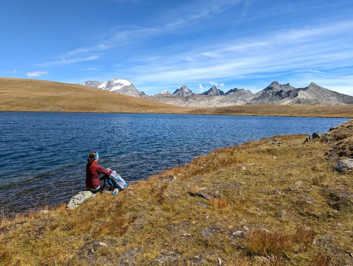 Linda sitzt am Ufer des Lago Rosset im Gran Paradiso Nationalpark