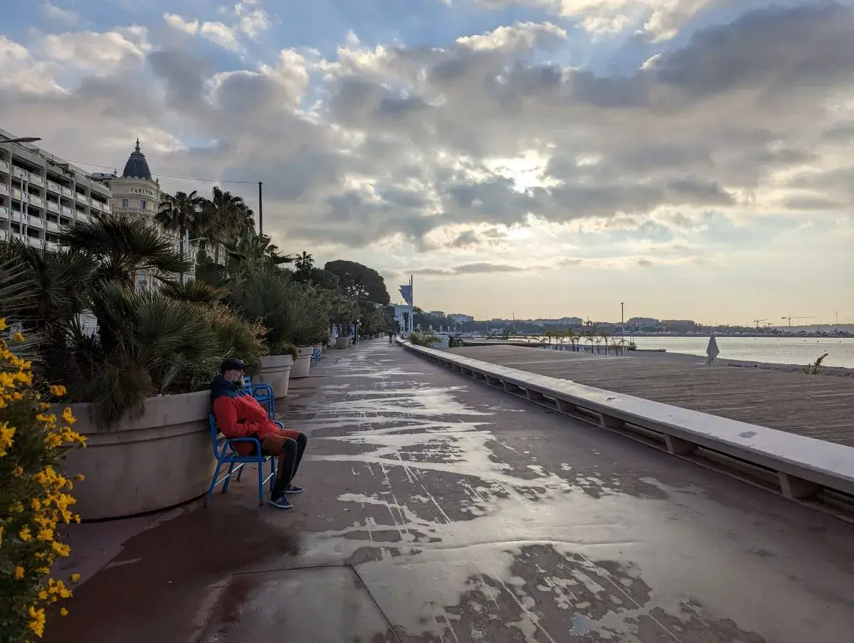 Linda sitzt an der Promenade de la Croisette am Strand von Cannes