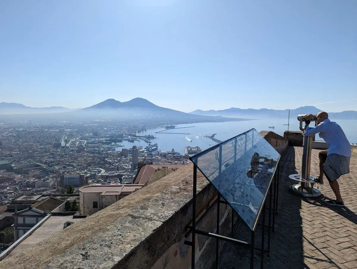 Jan guckt durch das Fernrohr, von dem der Ausblick über Neapel Altstadt bis zum Vesuv vom Castel Sant'Elmo reicht