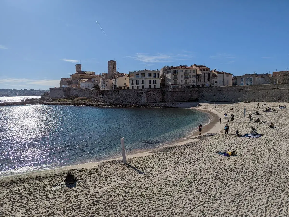 Stadtmauern und Strand von Antibes an einem strahlenden Somertag. Der halbmondförmige Sandstrand, auf dem Linda steht, ist nur einen Tagesausflug von Nizza entfernt