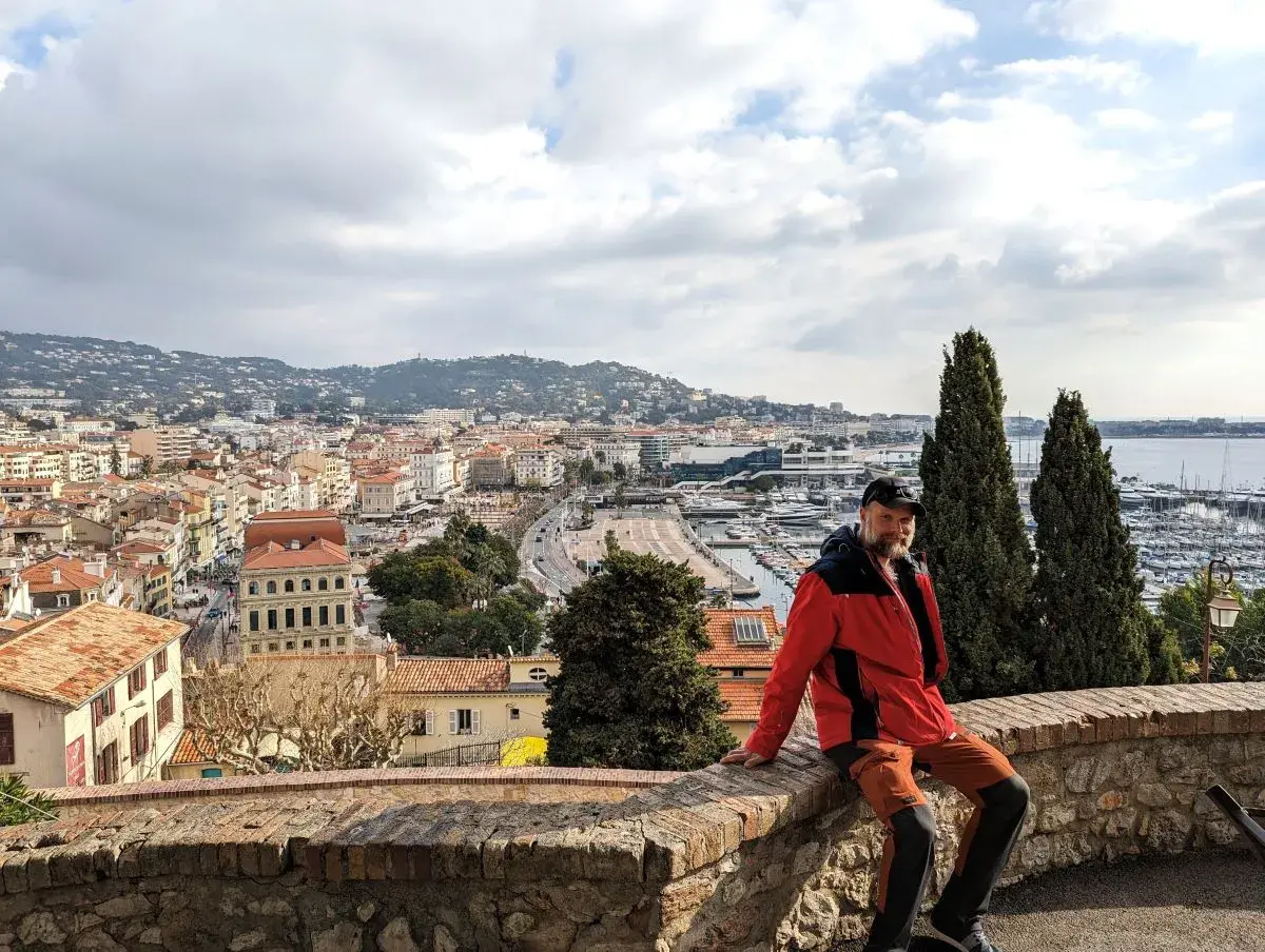 Jan sitzt auf der Festungsmauer, oberhalb des Zentrums von Cannes und betrachtet das Nizza Ausflugsziel Cannes von oben