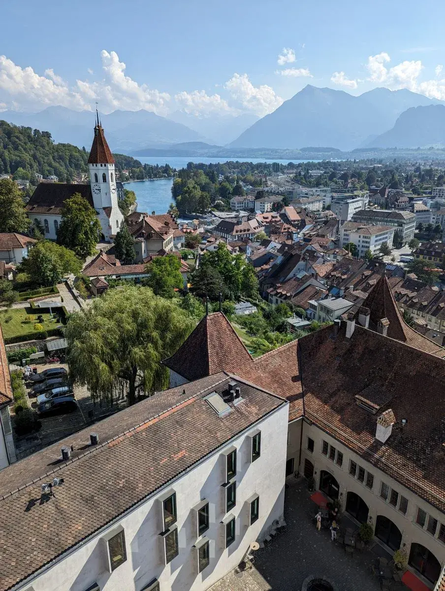 Blick vom Schloss Thun auf die Dächer der Stadt, den Thunersee und die Alpen