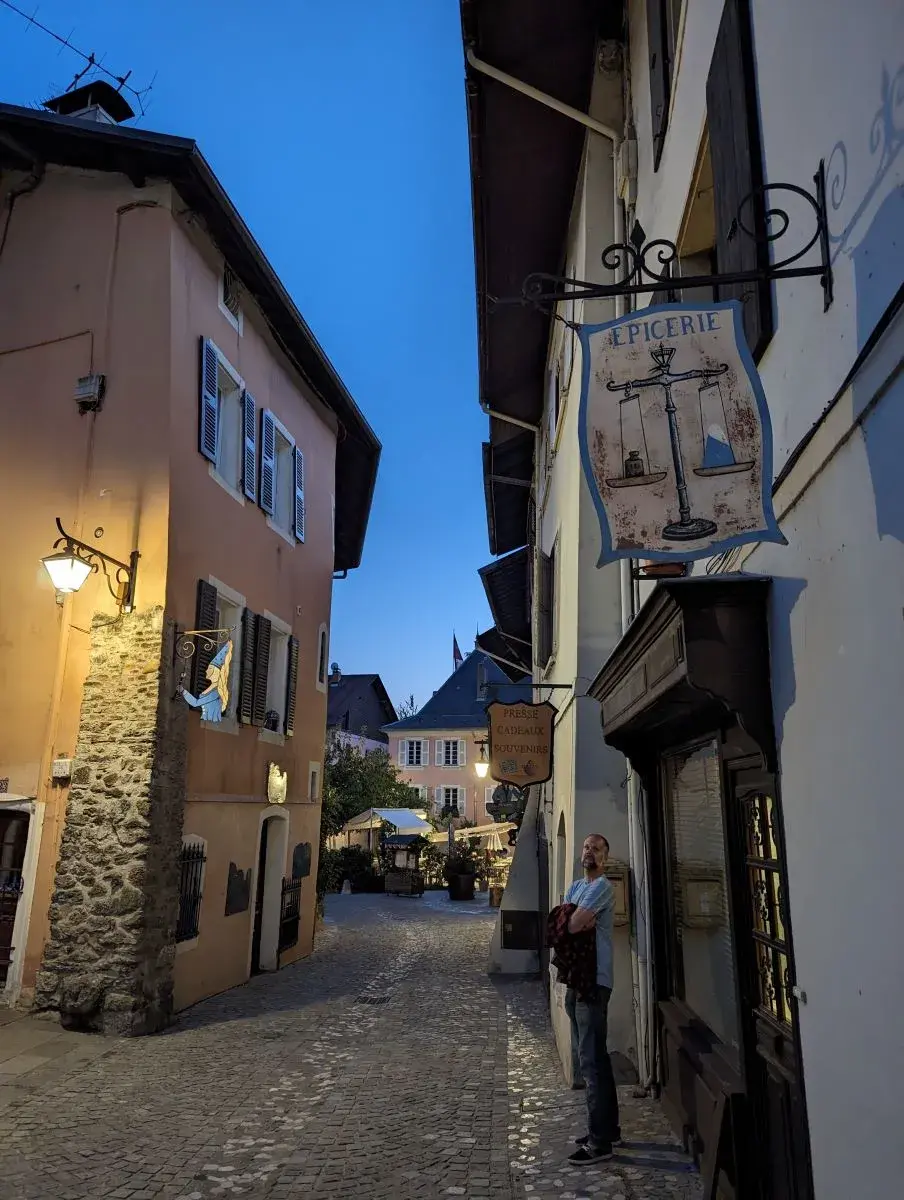 Jan steht in der abendlichen Altstadtstrasse von Conflans, Albertville