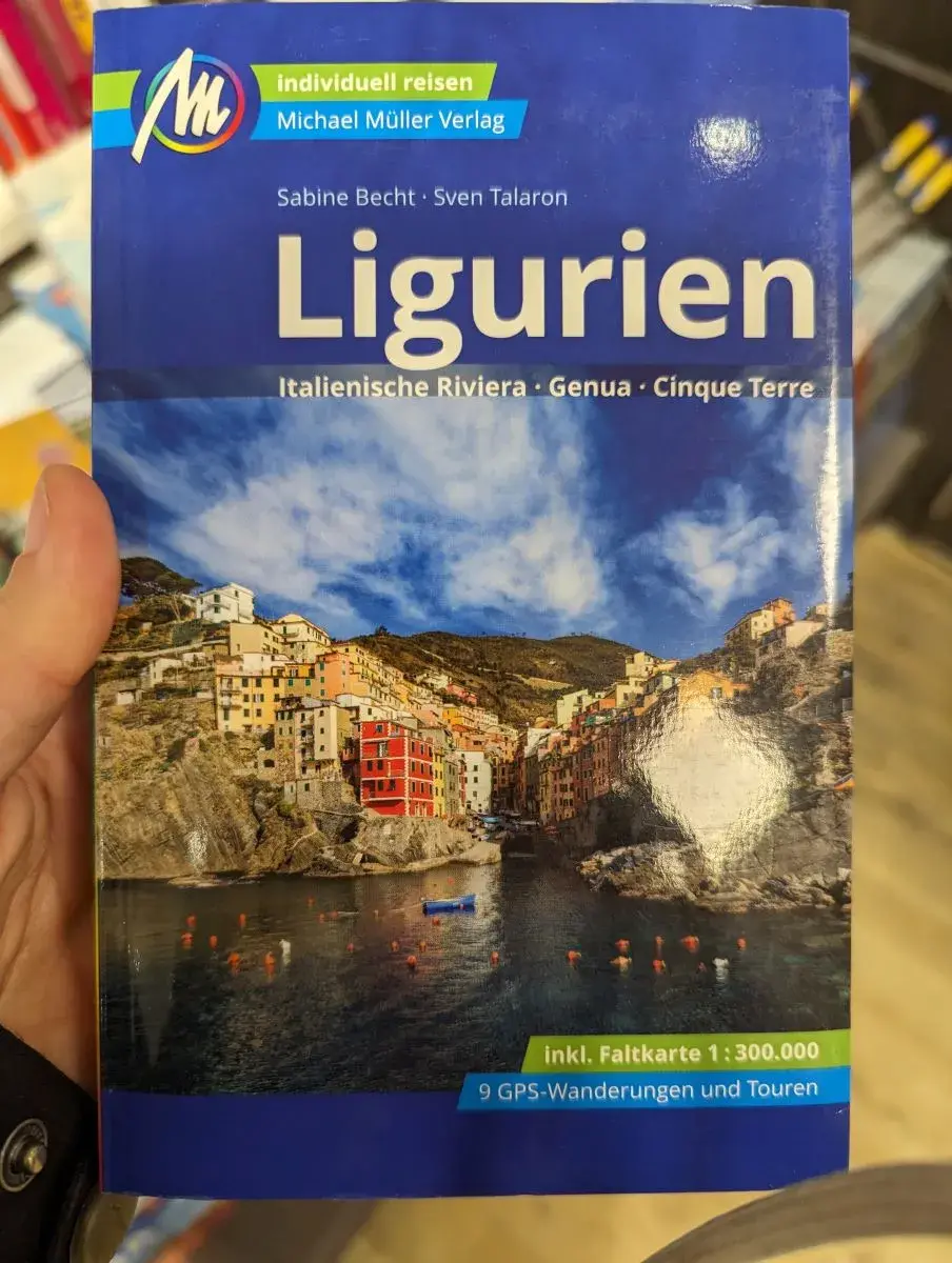 Linda hält den Reiseführer von Ligurien in der Hand