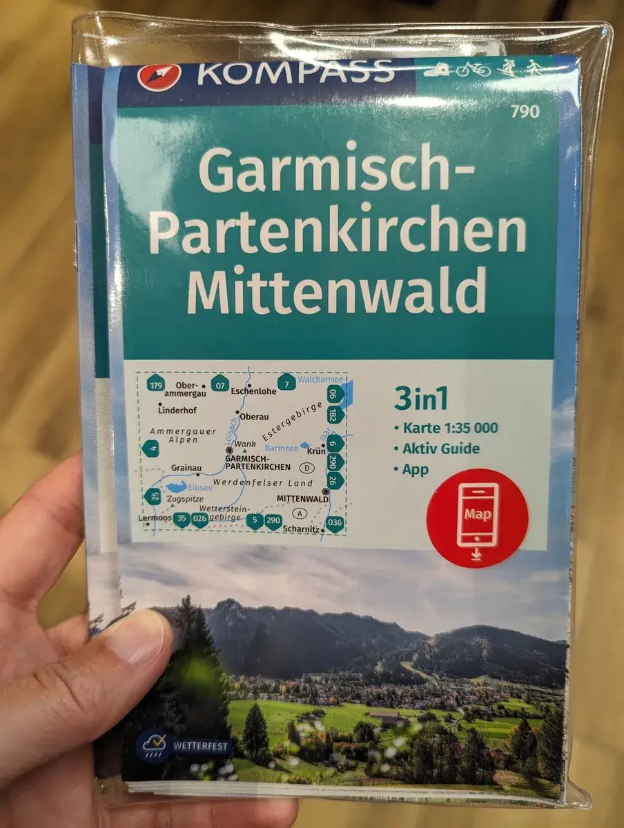 Linda hält die Kompass Wanderkarte von Mittenwald in der Hand