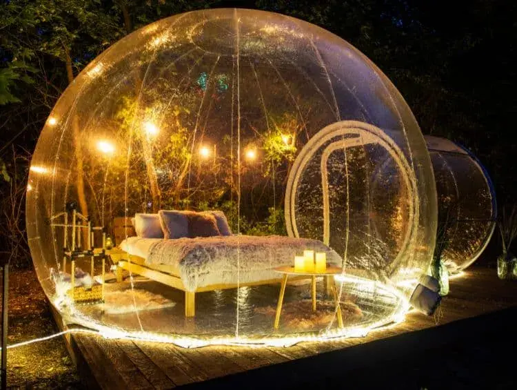 Beleuchtete Bubble Suite im Dunkeln mit einem Bett in der Mitte