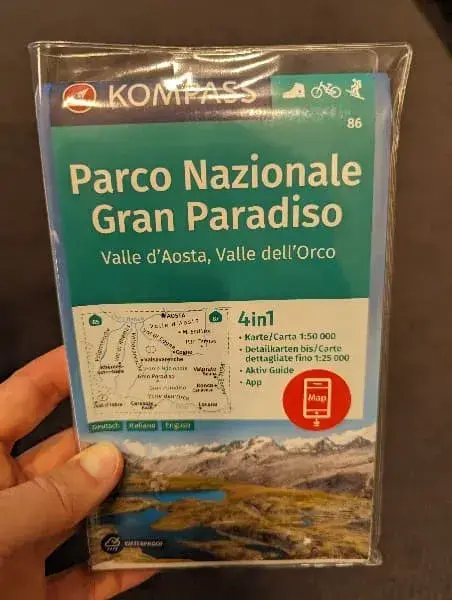Linda hält die Kompass Wanderkarte des Gran Paradiso Nationalparks in der Hand