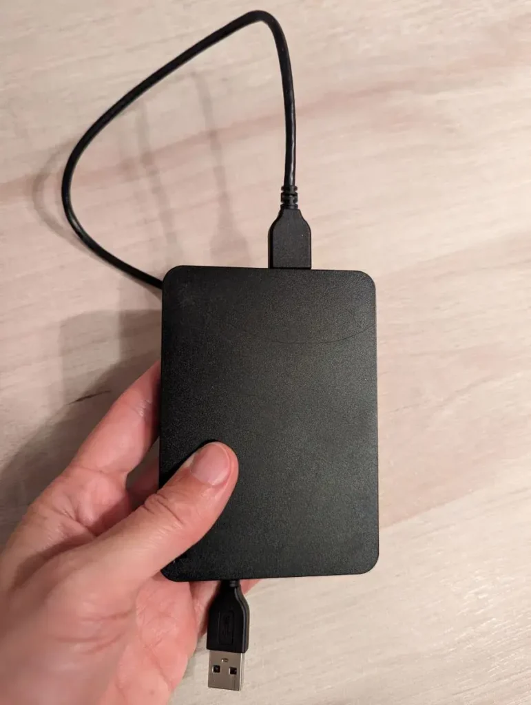 Linda hält eine schwarze Powerbank in der Hand, das perfekte Geschenk für Blogger
