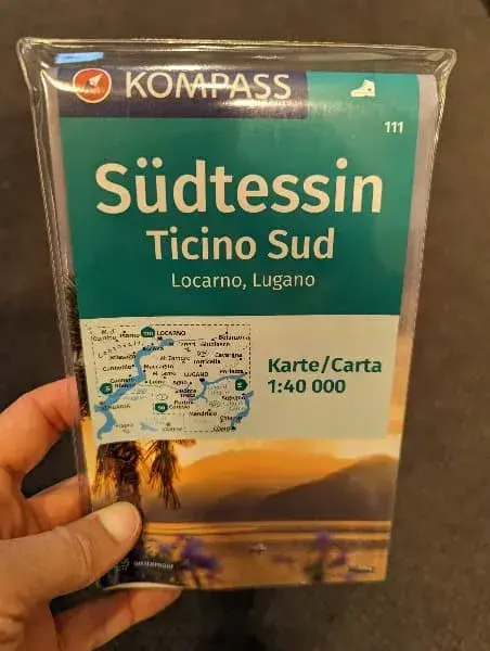 Linda hält die Wanderkarte über den Süden vom Tessin in der Hand