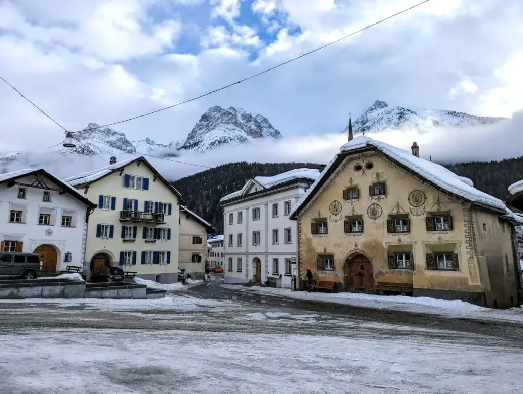 Hauptplatz in Scuol mit den Engadiner Bergen im Hintergrund und viel Eis und Schnee überall