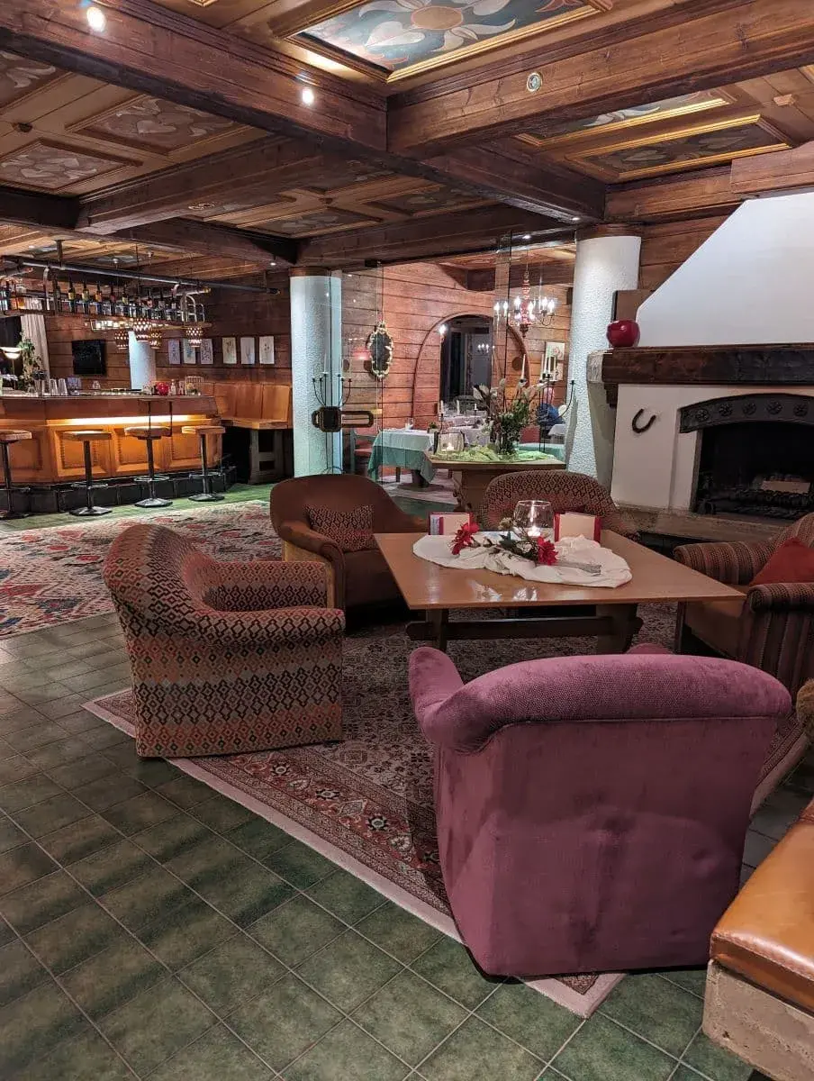 Gemütlicher Lobbybereich des Hotel St. Oswald mit großen Sesseln und Kamin