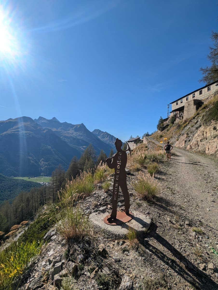 Eine Wanderung oberhalb von Cogne führt vorbei an der Silhouette eines Bergknappen, die an den historischen Minenbau erinnert. Der Weg verbindet Natur, Geschichte und Panorama – typisch für die Vielfalt im Aostatal.
