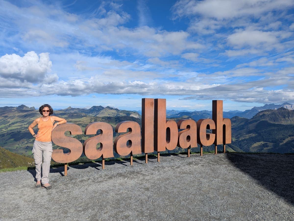 Linda steht beim großen "Saalbach"-Schriftzug an der Bergstation Schattberg Ost. Der Platz ist ein beliebtes Fotomotiv am Einstieg zum Pinzgauer Spaziergang.