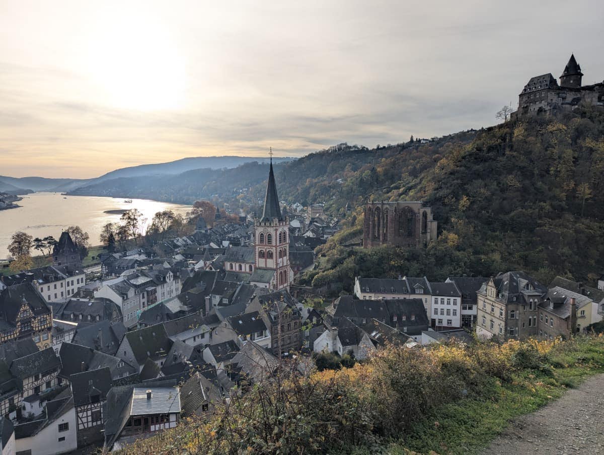 Blick vom RheinBurgenWeg über die Dächer von Bacharach mit der Pfarrkirche St. Peter, der Wernerkapelle und der Burg Stahleck hoch über dem Ort im Mittelrheintal.