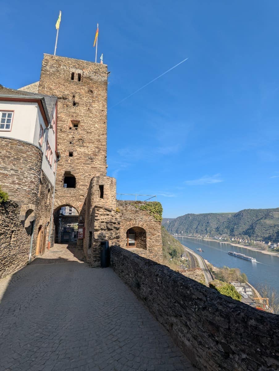 Blick vom Innenhof der Burg Rheinfels am RheinBurgenWeg über die alten Mauern der Burgruine und den Rhein tief unten im Mittelrheintal bei St. Goar.