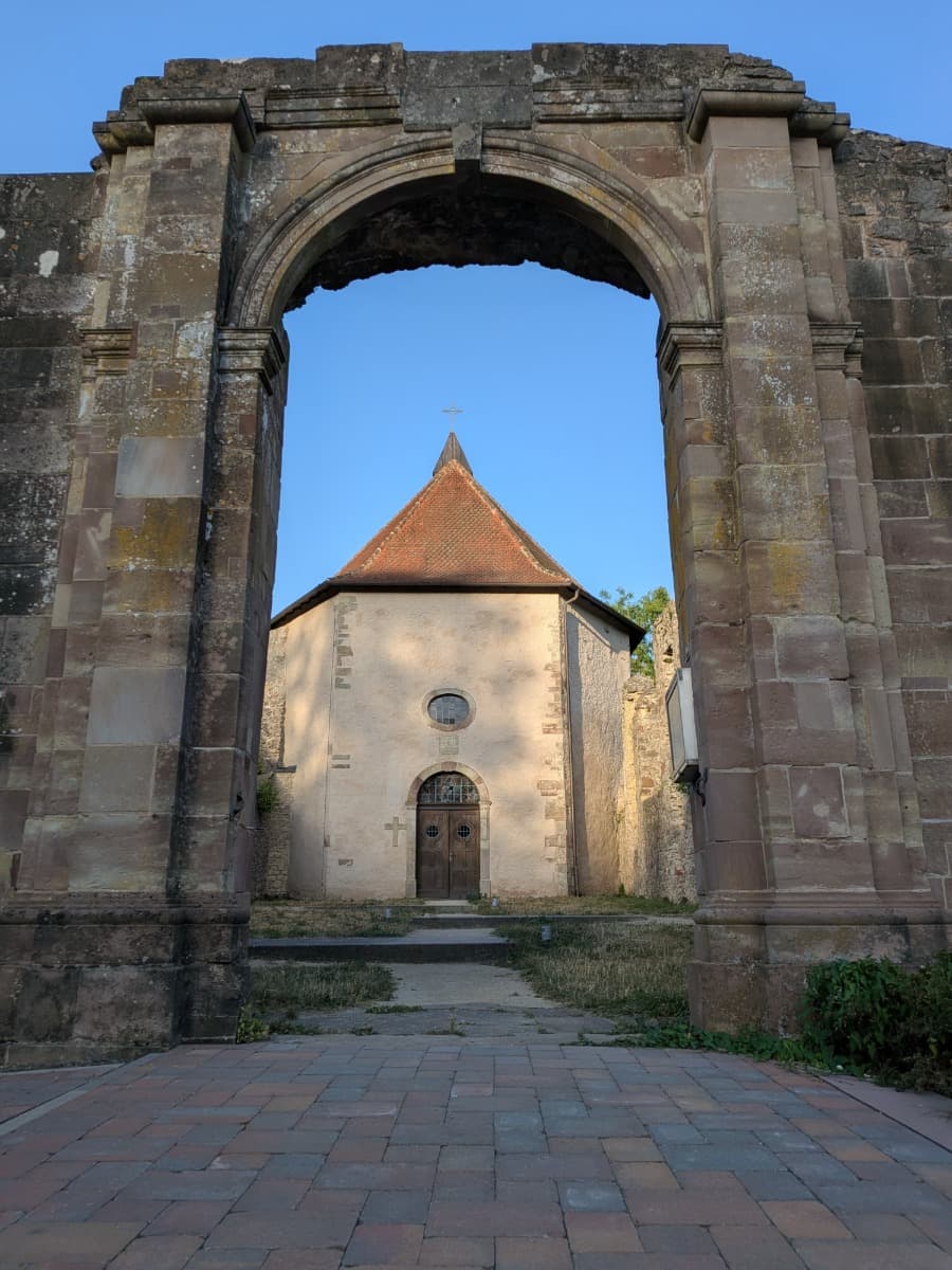 Ein mächtiger Sandsteinbogen der Klosterruine Gräfinthal rahmt die kleine Kapelle im ehemaligen Wilhelmitenkloster am Bliessteig ein.
