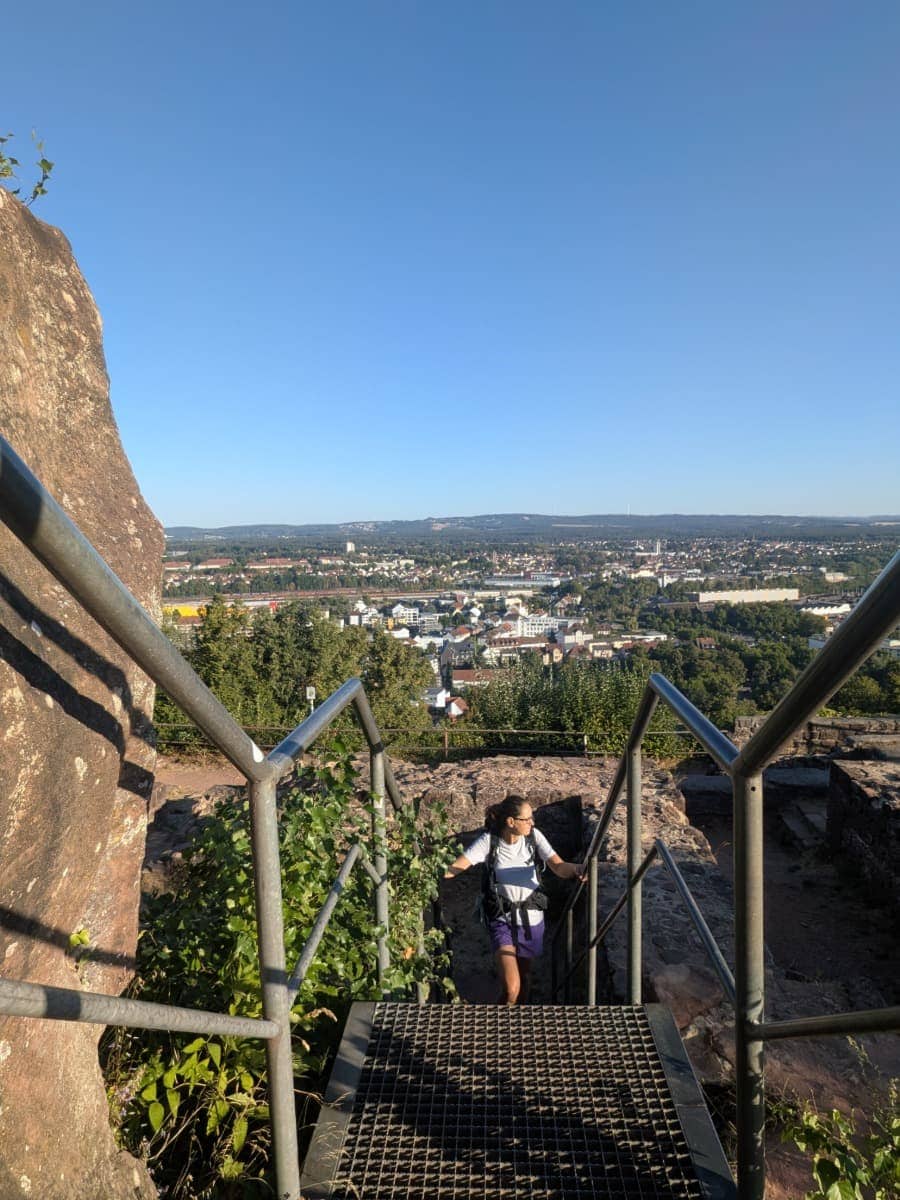 Linda steigt durch die Ruinen der Vauban-Festung auf dem Homburger Schlossberg hinauf, mit weitem Blick über Homburg am Bliessteig.