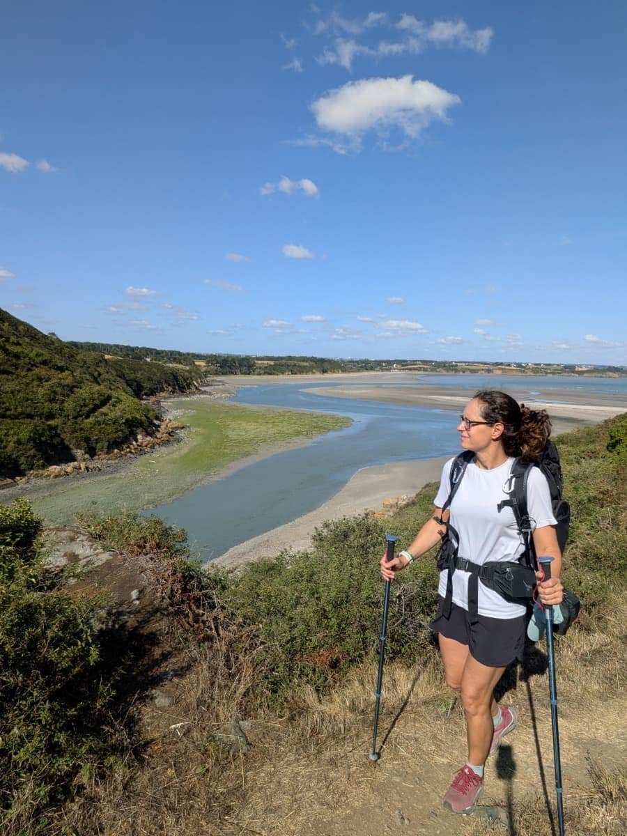 Linda genießt den Ausblick über die Flussmündung des Guessant und Sandbänke auf dem Zöllnerpfad GR34 an der bretonischen Küste.