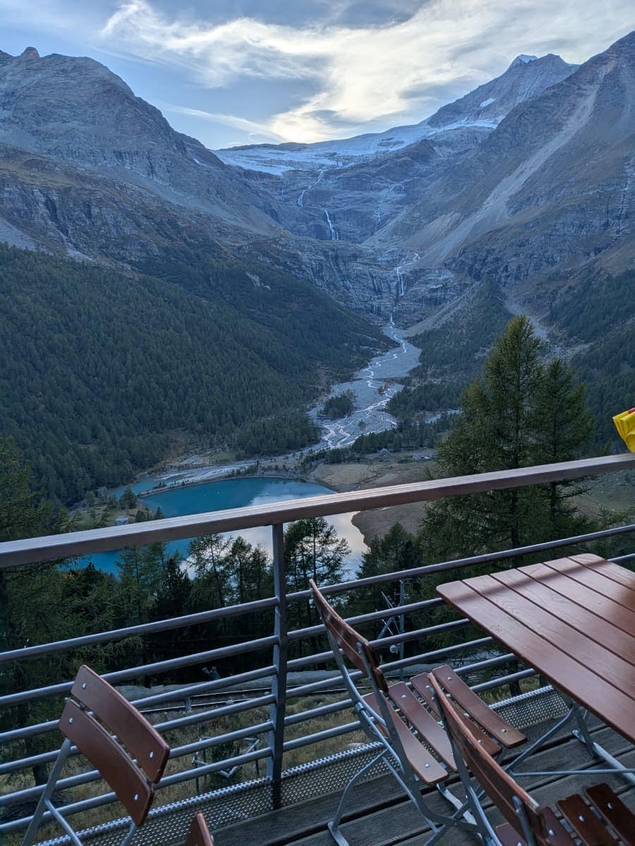 Von der Terrasse auf Alp Grüm öffnet sich der Blick auf den türkisfarbenen Lagh da Palü und den Palügletscher, der zwischen steilen Felswänden aus der Berninagruppe ins Tal hinabzieht.